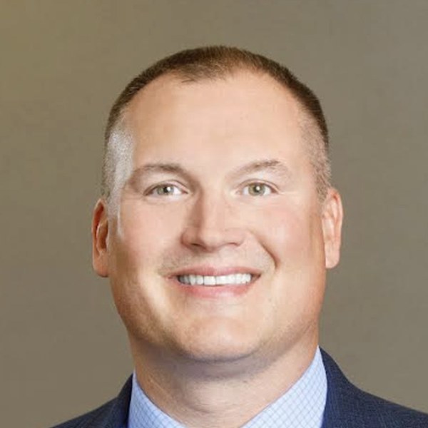 Portrait of Michael Burde, Ph.D., founder of Burde Leadership Group, smiling in a navy suit